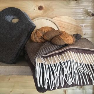 Wolldecke, Filztasche und Garn im Regal