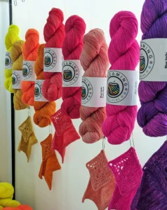 verschiedene handgefärbte Wollstränge mit Maschenproben