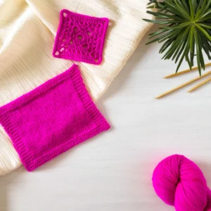 handgefärbte Sockenwolle in Neon Pink mit einer gehäkelten und einer gestrickten Maschenprobe
